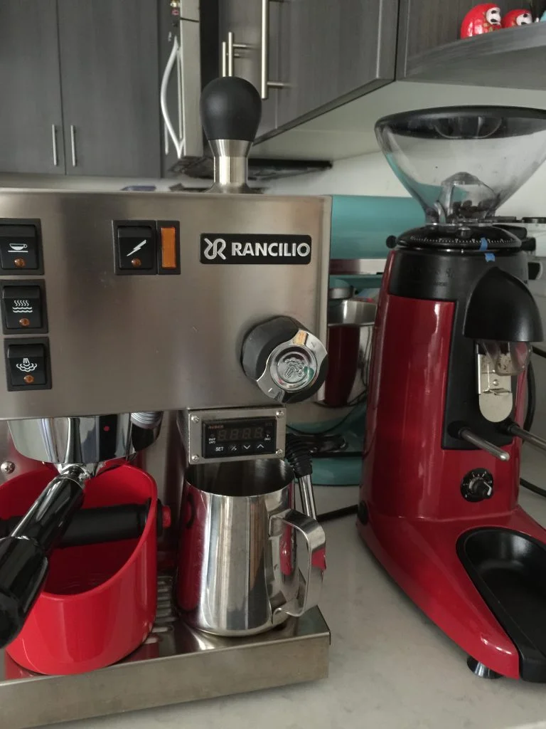 A Rancilio Silvia coffee machine and a coffee pot on a kitchen counter.