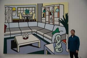 A man standing in front of a large painting.