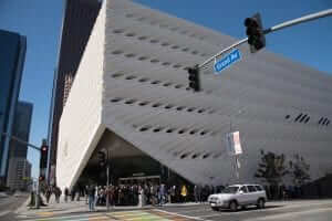 A crowd of people standing in front of a large white building.
