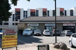 A parking lot with cars parked in front of a building.