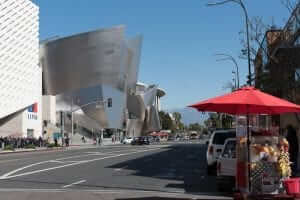 A red umbrella sits on a street in front of a building.