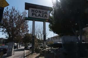 A honda plaza sign sits on a street corner.