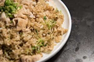 A plate of chicken fried rice on a table.