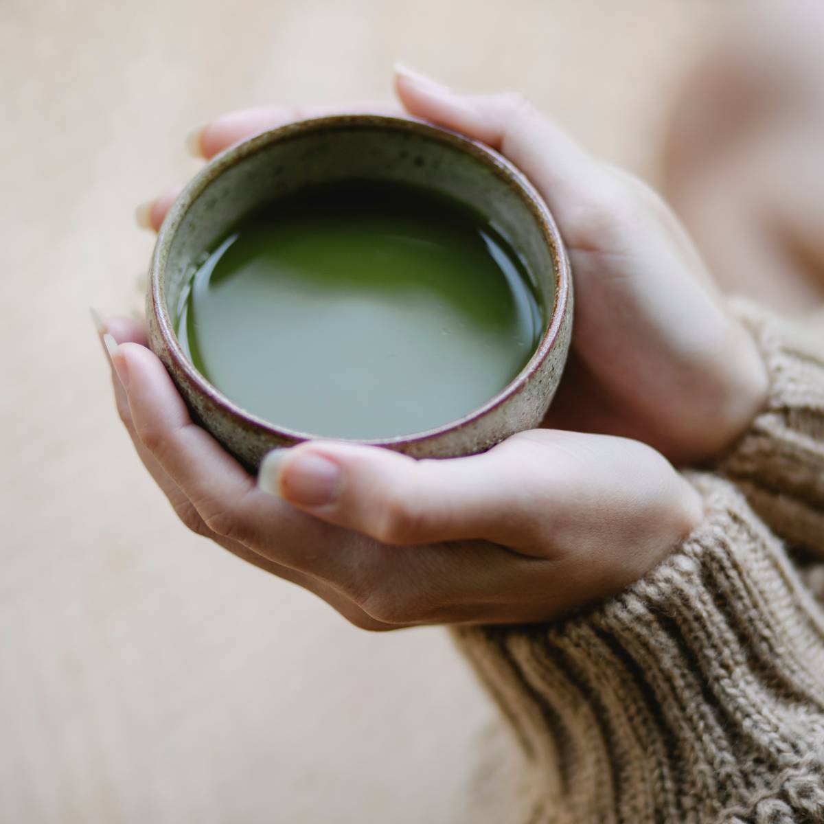 woman holding a cup of hot matcha