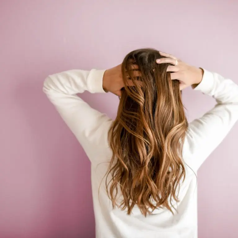 A woman facing the wall while touching her hair